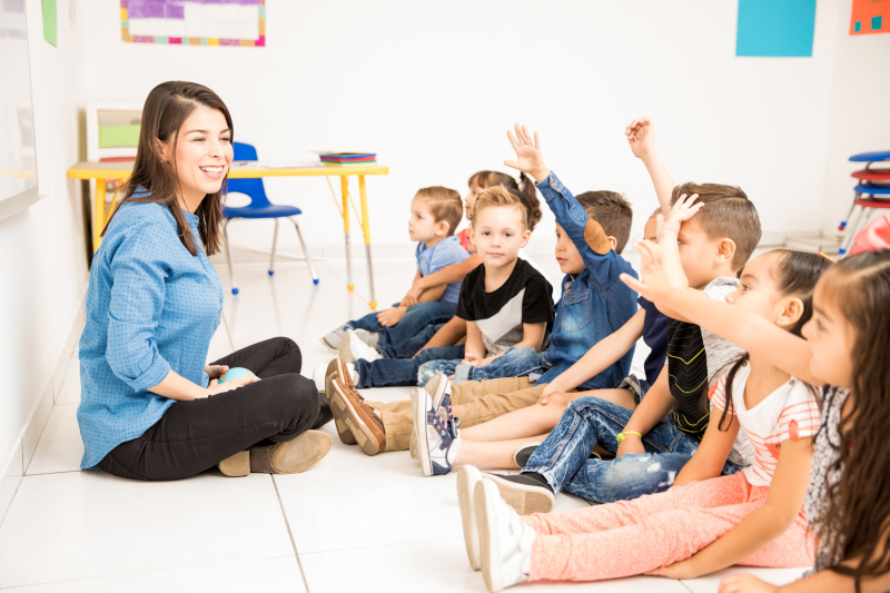 Beautiful,Preschool,Teacher,And,Her,Group,Of,Students,Raising,Their